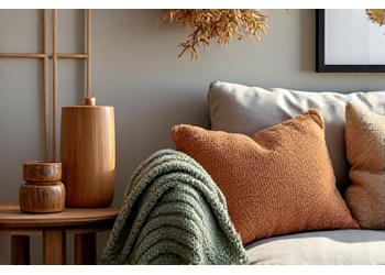 A cozy autumnal living room scene featuring wooden decorative items easily transitionable with seasonal textiles like chunky knit throws and warm-toned cushions, bathed in soft, inviting light.